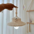 Abat-jour en macramé suspendu dans un salon, créant une ambiance chaleureuse et naturelle.