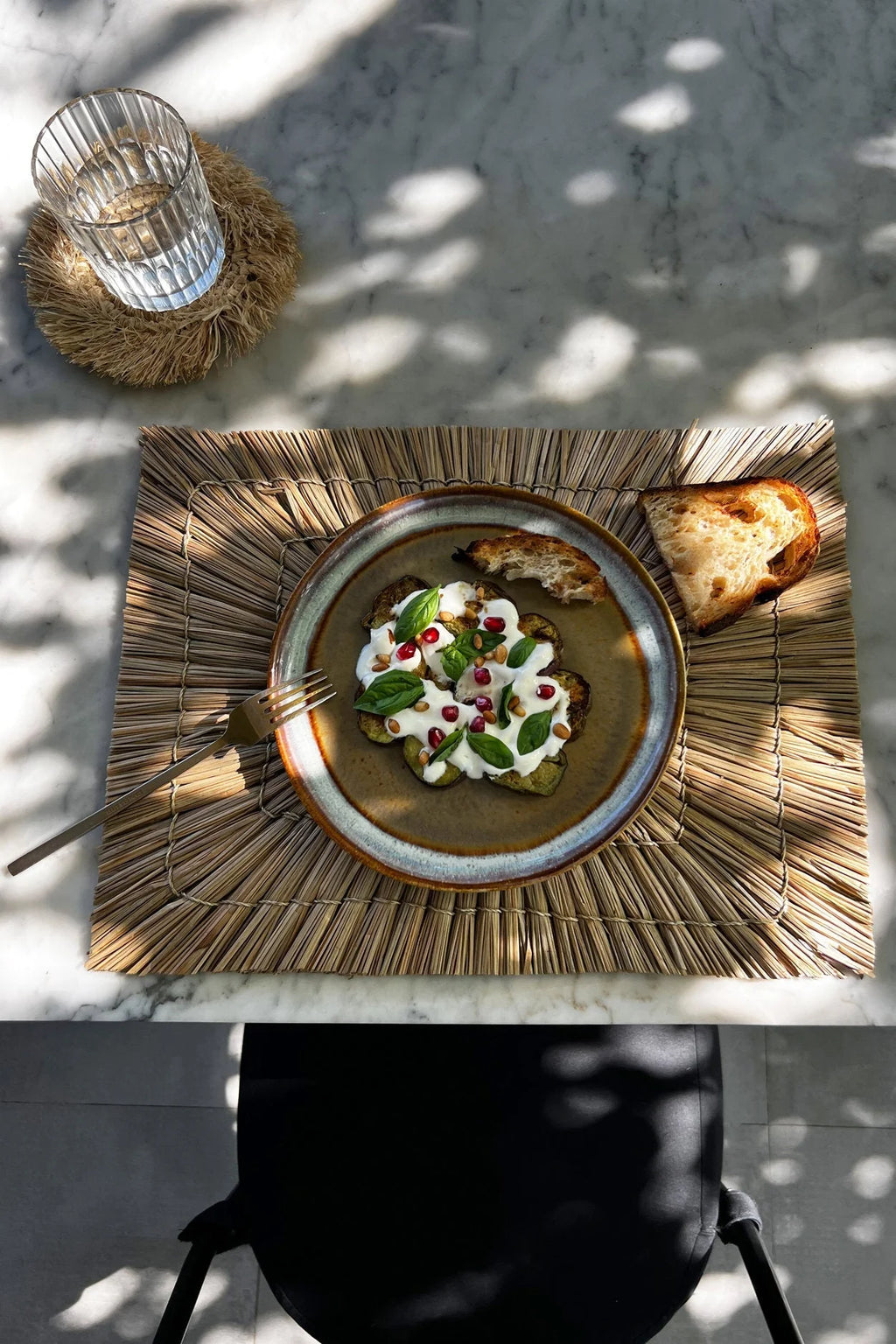 Assiette en grès émaillé brun mat et bord bleu avec salade aux grenades