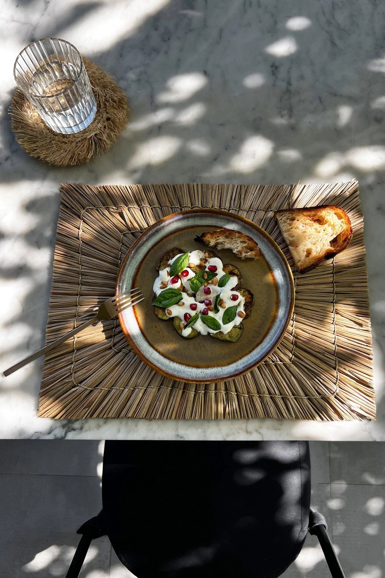 Assiette en grès émaillé brun mat et bord bleu avec salade aux grenades