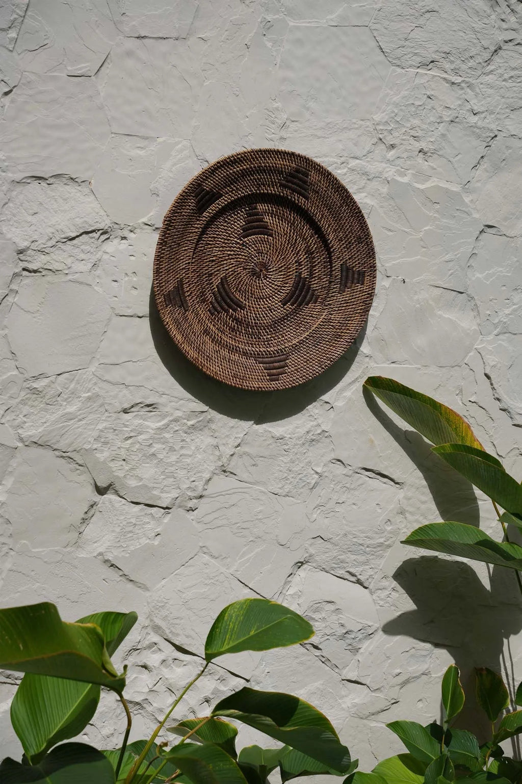 Panier décoratif en rotin brun tressé avec motif en spirale et triangles, diamètre 40 cm