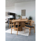 Table à manger en bois clair avec base cannelée et chaises noires