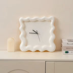 Horloge ondulée blanche posée sur un meuble, décoration minimaliste.