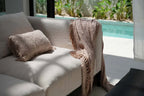 Couverture jetable beige texturée à franges sur canapé clair