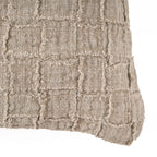 Housse de coussin lin beige à carreaux relief contre mur rustique