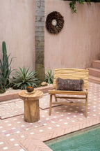 Chaise longue en bois clair avec coussin tissé sombre, idéale pour l’extérieur