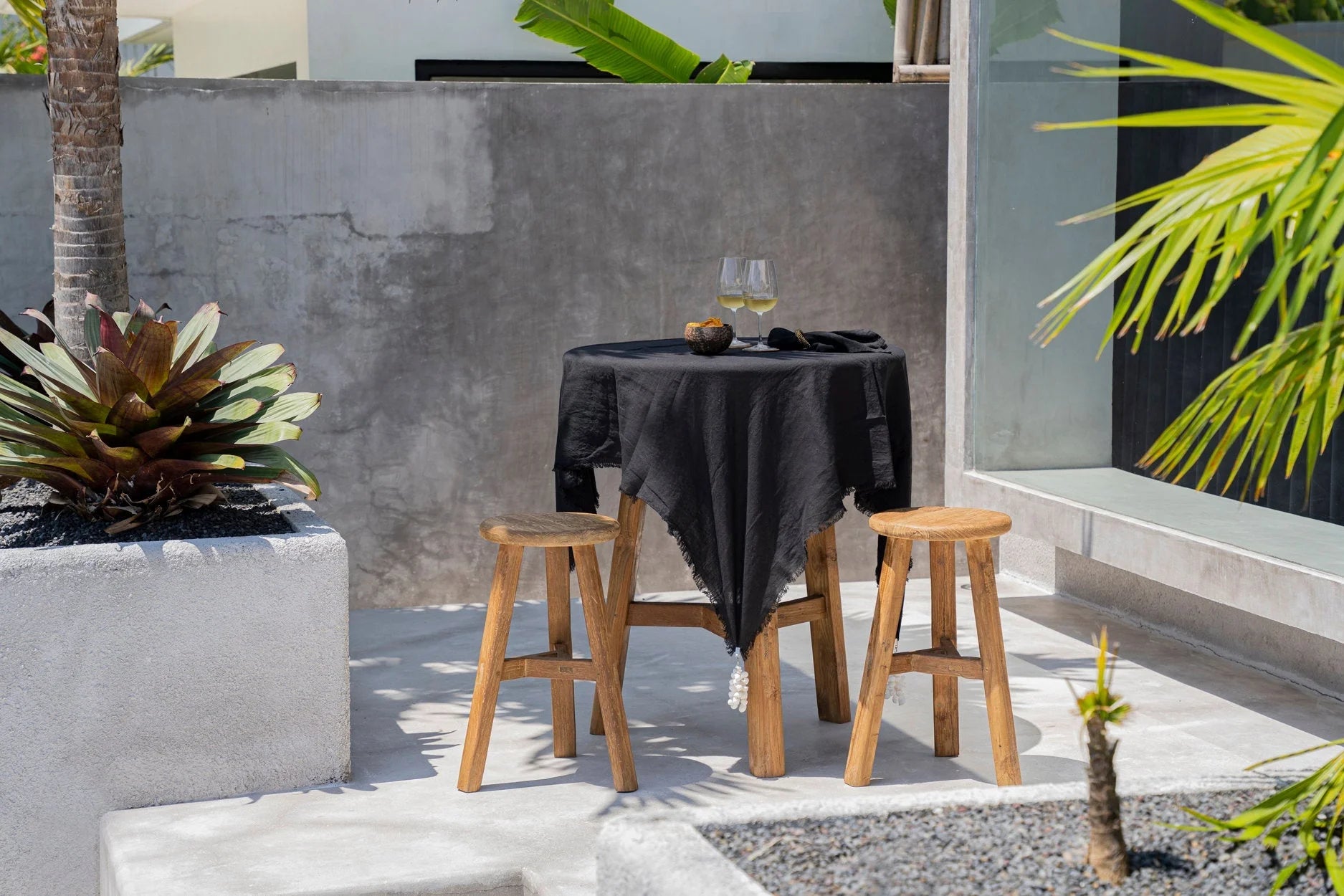 Nappe carrée en lin noir 150x150 cm sur table extérieure avec deux tabourets