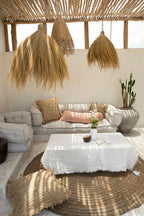 Coin salon extérieur avec canapé, table basse et décoration en fibres naturelles