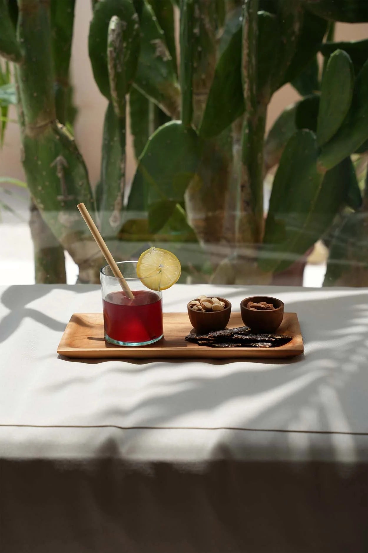 Verre de jus de fruits rouge avec tranche de citron et paille en bambou naturel
