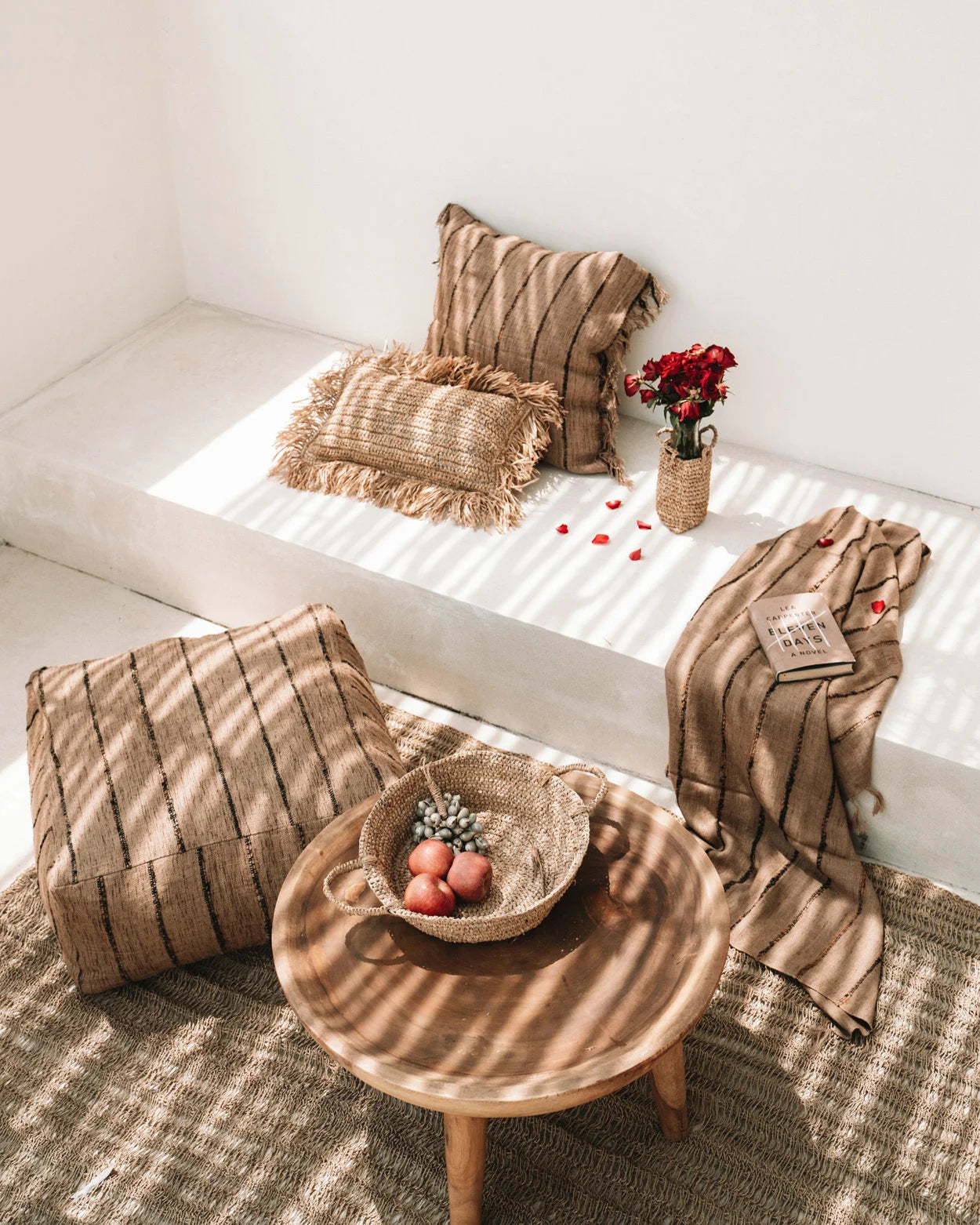 Table ronde en bois à trois pieds avec panier en raphia naturel sur le dessus