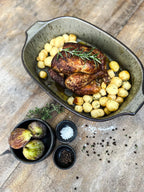 Poulet rôti avec pommes de terre et romarin dans un plateau en céramique vert grisâtre