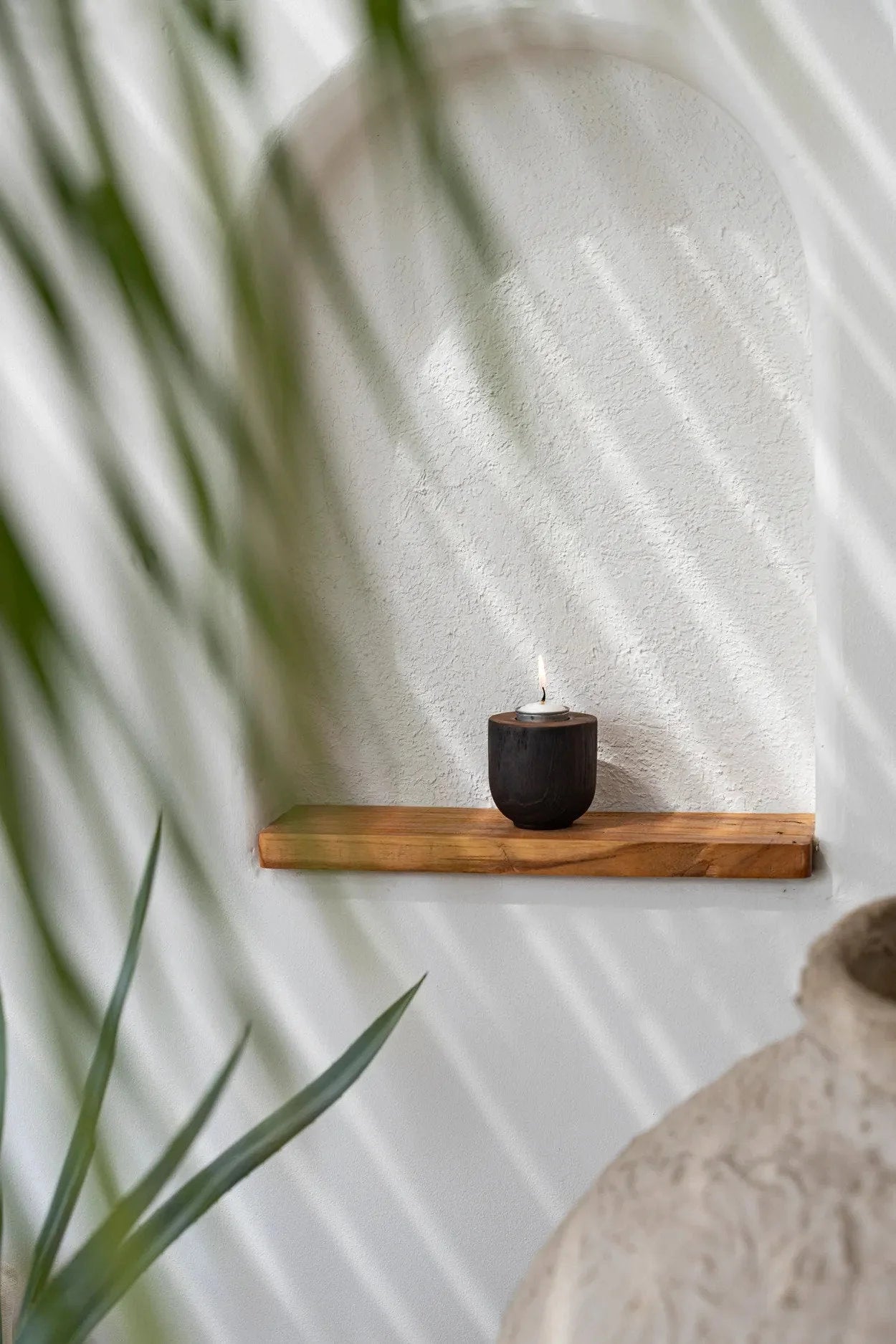 Porte-bougie en teck noir minimaliste avec bougie allumée et flamme chaleureuse