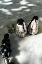 Paire de salières et poivrières en coquillages coniques élégants à motif tacheté noir et blanc