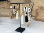Boucles d’oreilles bohèmes à pompons, raphia naturel et coquillages blancs sur support noir