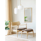 Fauteuil en bois clair avec siège et dossier rembourrés marron, globe opalin blanc strié Ø30 cm