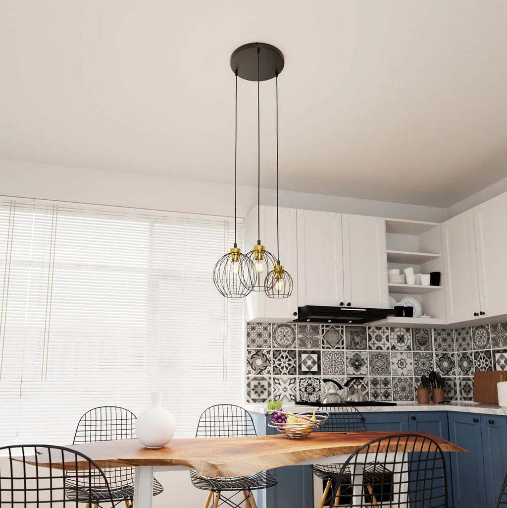 Lampe suspendue noire filaire avec douilles dorées en grappe Ø24 cm au-dessus table en bois