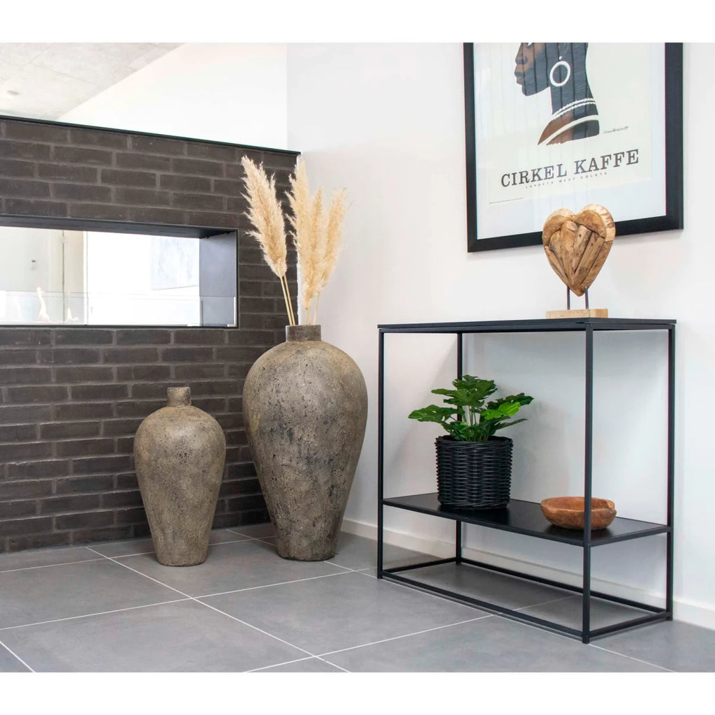 Vase céramique gris texturé haut, col étroit et base évasée sur console noire métallique 80x36 cm