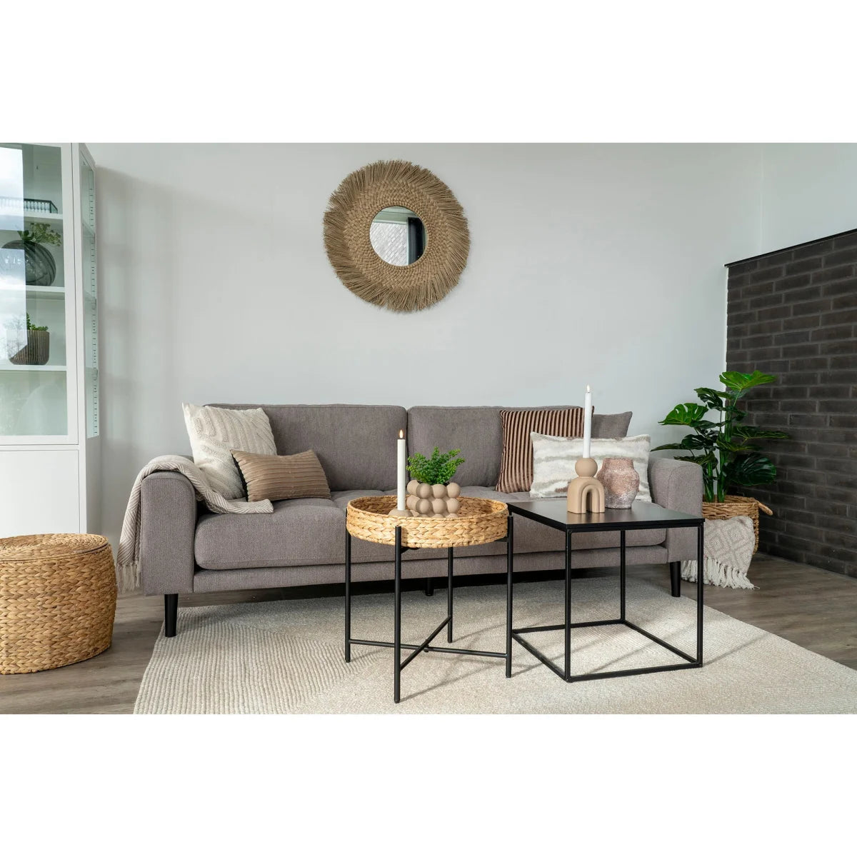 Canapé en tissu gris avec coussins et couverture drapée