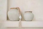 Vase décoratif en terre cuite et raphia avec vases gris clair, textures, bois et tassel